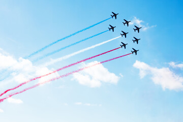 Group of planes fly with color trail in blue red white - obrazy, fototapety, plakaty
