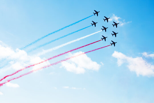 Group of planes fly with color trail in blue red white