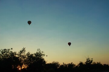 Hot air balloons dance in twilight's embrace/ Colors ablaze against the sun's last trace/ Floating...