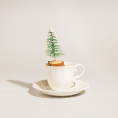 White cup with Cristmas tree on table. Hot chocolate or coffe time. Holidays concept.