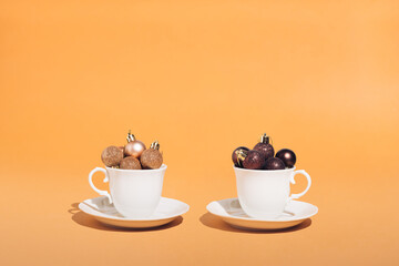 White cups with Cristmas bubbles on table. Hot chocolate or coffe time. Holidays concept.