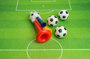 Football soccer triple fan trumpet with toy football on green grass