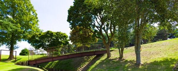 青空のゴルフ場・丘に挟まれ囲まれた川のようなカート道と錆びて古い橋のパノラマ（千葉県木更津市）