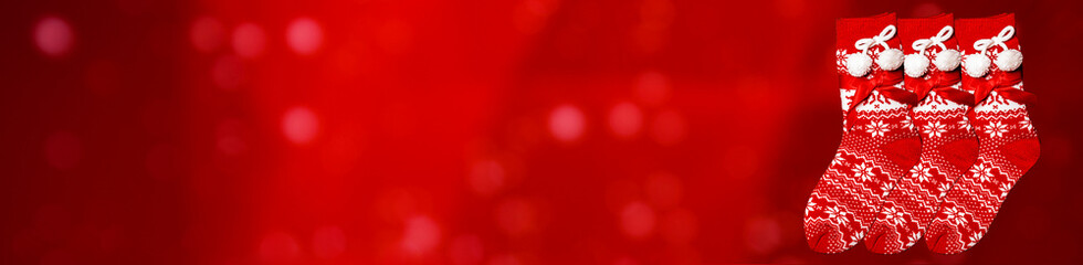 Christmas Red Socks on the Glitter sparkling abstract red bokeh defocused background, border design...