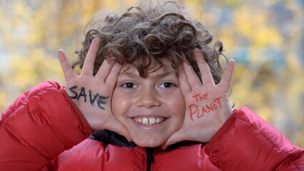 Boy child 8 years old - Hand with written Save the planet - Global warming and climate change concept - air pollution of the air due to the heating of the houses of the buildings in the city