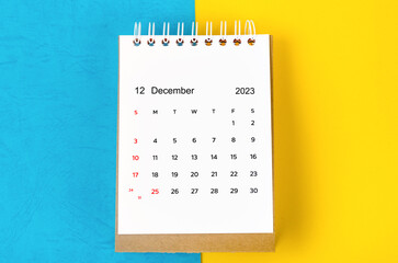 The December 2023 Monthly desk calendar for 2023 year on blue and yellow background.