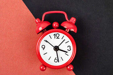 The Red vintage alarm clock on red and black colour background.