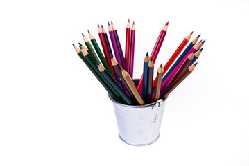 multi-colored pencils in a wine glass and a bucket. Selective blurred a group of coloring pencils in a wine glass on the isolated white or black background , Modern art. Modern