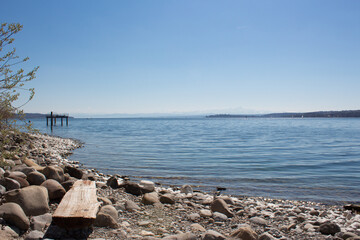 Fototapeta na wymiar Rocks and a wooden bench at Lake Constance, Germany