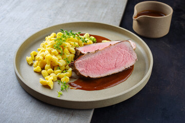 Tafelspitz Braten Scheiben vom Kalb mit schwäbische Spärtle serviert mit Dunkelbier Sauce als close-up auf einem Design Teller 