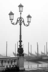 Fototapeta na wymiar Laterne mit Gondeln im venezianischen Nebel
