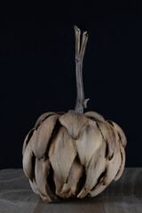 Dried artichoke isolated on black background