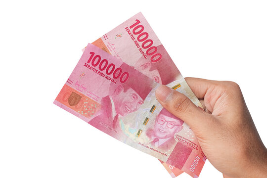 Hand holding one hundred thousand rupiah banknote isolated on a white background. financial concept