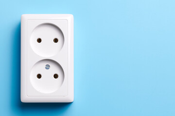 White double socket isolated on blue background. Electric lighting concept