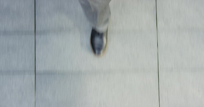 Top view of businessman, feet and walking in city street for traveling, morning commute and rushing in a hurry with speed, footsteps or journey. Closeup executive shoes, foot and walk to work in road