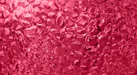 Abstract Magenta Background of uneven convex glass texture with ripple effect, water or ice imitation. Color of the year 2023