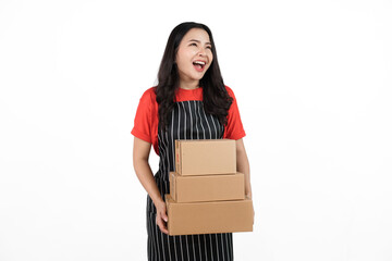 Holding package box, Food shop owner concept, Smiling young confident asian woman in black apron and red t-shirt isolated on white background.