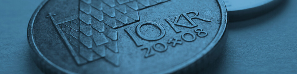 Norwegian coins lie on gray surface. 10 Norges kroner coin. Currency of Norway. News about economy...