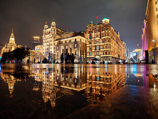 Shanghai bund landscape in rainy day, perfect reflection of historical building landmarks in puddles on sidewalks.