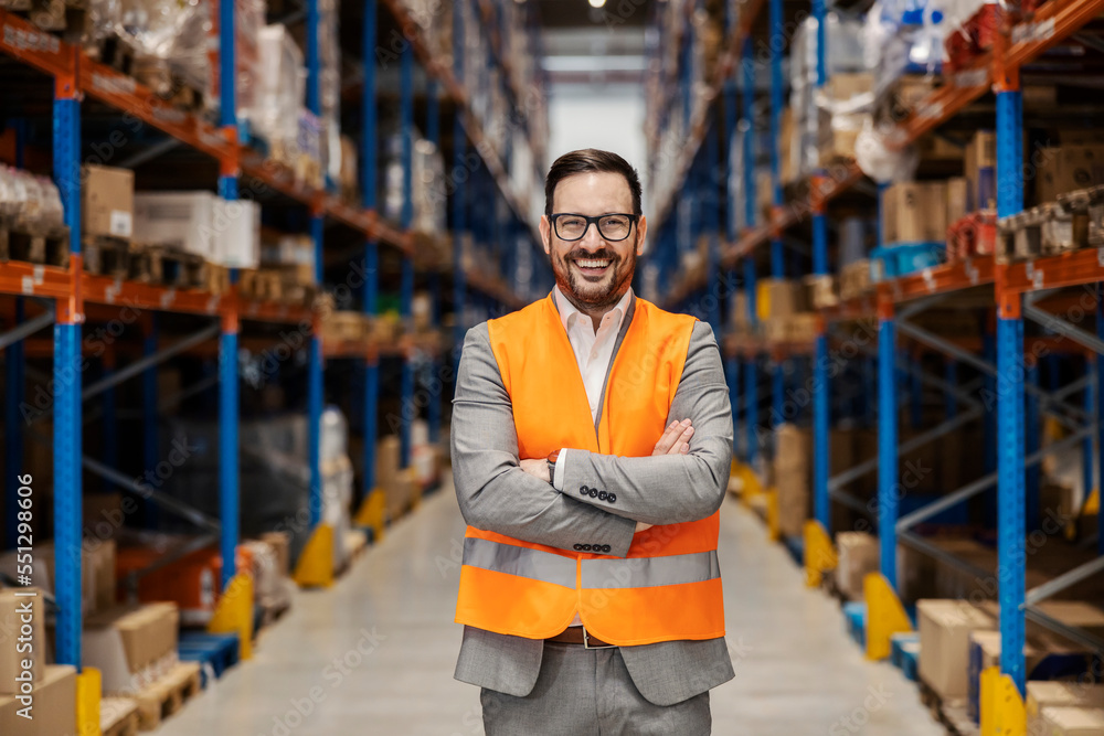 Poster A successful small business owner is standing in warehouse and smiling at the camera.