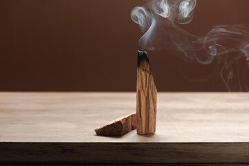 Palo Santo, holy tree stick burning on woodwn background with space for text