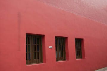 Fototapeta na wymiar vintage color windows on red wall in a buildings 