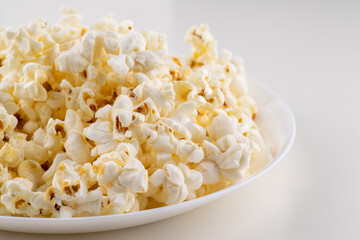 White plate with popcorn isolated on white background
