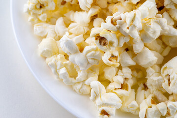 White plate with popcorn isolated on white background