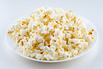 White plate with popcorn isolated on white background