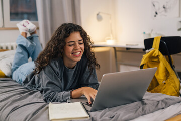 Happy young woman works on laptop, learn