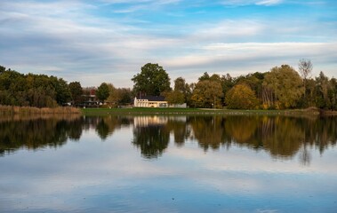 Fototapeta na wymiar Rotselaar, Flemish Brabant Region, Belgium - Panoramic view over the De Plas water pond with reflecting trees in autumn colors