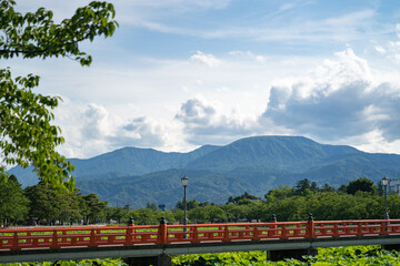 高田城のお堀の赤い橋からの妙高の山と夏雲