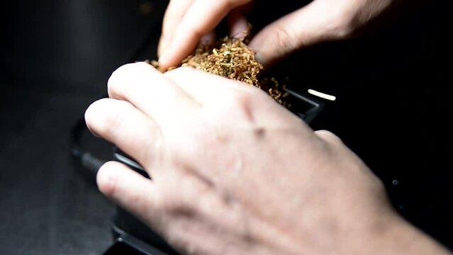 The process of putting tobacco into cigarette cases with a semi-automatic machine