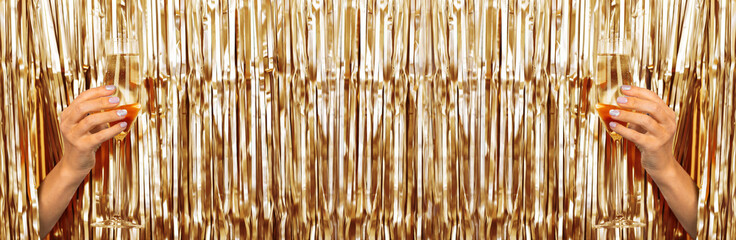 Woman hands holding glass of champagne on metallic golden background with copy space. Merry xmas and Happy new year 2023 background. Winter holiday celebration. Horizontal banner for web design