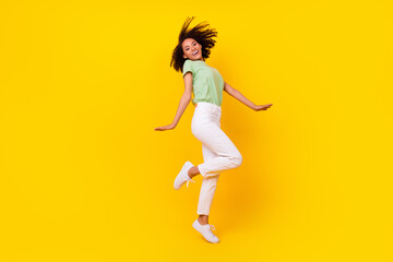 Fototapeta na wymiar Full size photo of young pretty adorable gorgeous nice perfect woman wear stylish casual wear dancing showing sneakers isolated on yellow color background