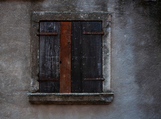 window with closed wooden shutters, city of Verona in Italy