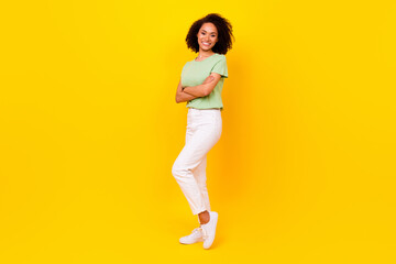 Fototapeta na wymiar Full length photo of young adorable gorgeous nice pretty woman wear casual stylish clothes folded hands toothy beaming successful isolated on yellow color background