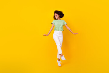 Fototapeta na wymiar Full length photo of young adorable cute sporty woman wear green t-shirt dancing celebrating party menstruation period isolated on yellow color background