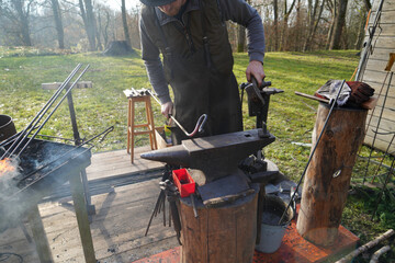 Blacksmith at handwork and glowing coals and iron