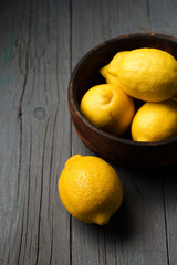 lemons in the bowl on a wooden background