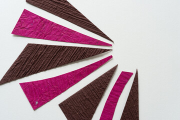 heavily textured paper triangles arranged on blank paper in a radial plan