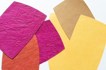 rounded orange, pink, yellow, and sand brown paper shapes on blank paper