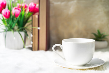 Coffee cup with book stacked on table