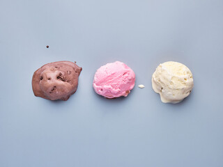 strawberry, chocolate and vanilla ice cream scoops isolated on a light background