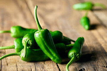 Green Padron peppers on wooden background