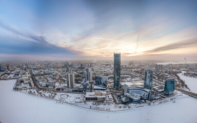 Fototapeta premium Yekaterinburg city with Buildings of Regional Government and Parliament, Dramatic Theatre, Iset Tower, Yeltsin Center, panoramic view at winter sunset.
