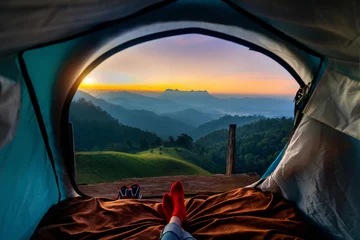  Woman cross leg on blanket in camping tent with sleeping bags on mountain hill. view from inside with Doi luang chiang dao mountains. © tawatchai1990
