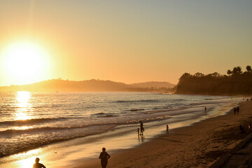 Sunset on the beach surrounded by rocky shores