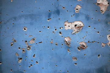 Holes from artillery shell fragments in the wall of an apartment building. Damage to a residential...