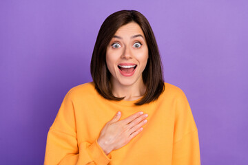Photo of young adorable cute girlish lady wear orange sweater touch chest surprised open mouth unbelievable reaction isolated on purple color background